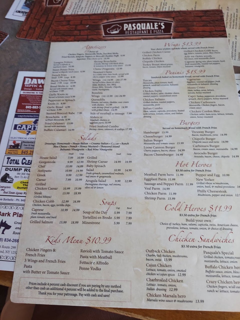 Restaurant menu beside a pizza slice.